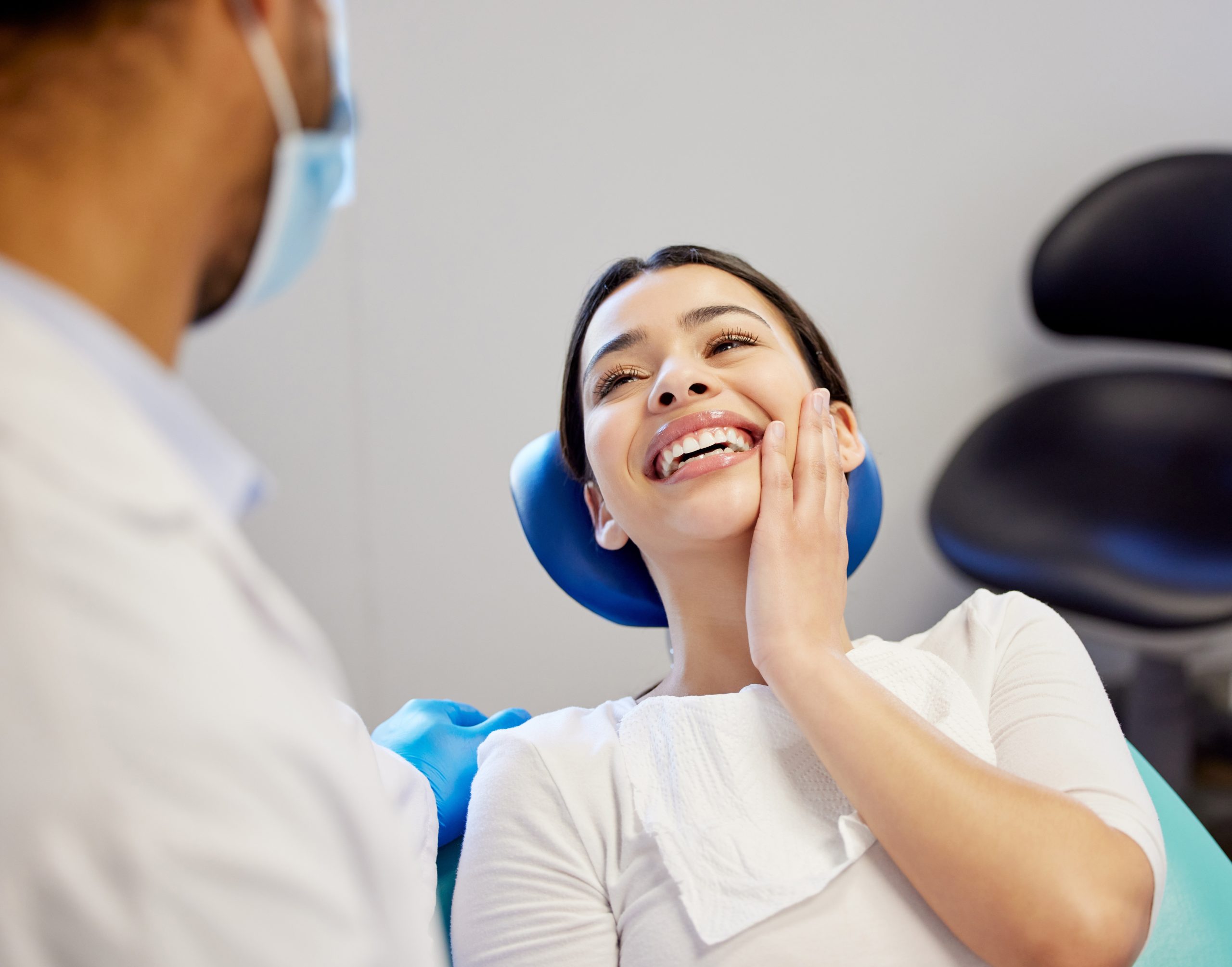 Female patient smiling in dental chair during cosmetic dentistry treatment