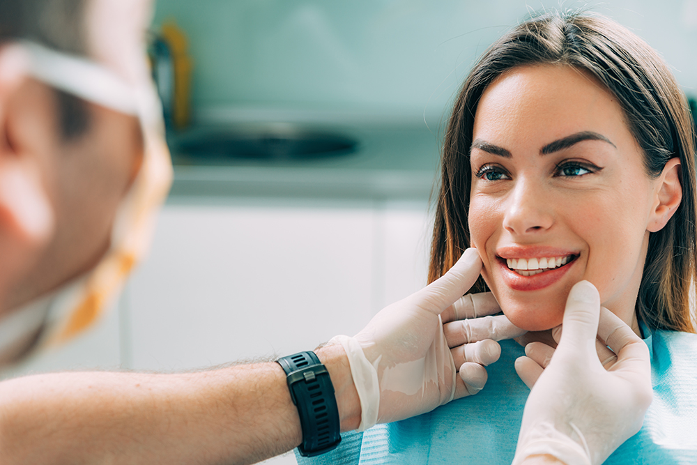 Patient smiling after crown lengthening procedure in a dental office