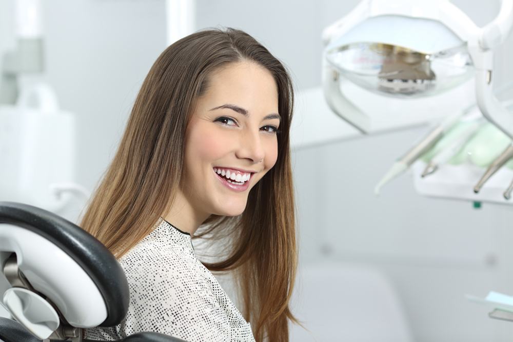 Female patient smiling in a dental chair during a dental visit